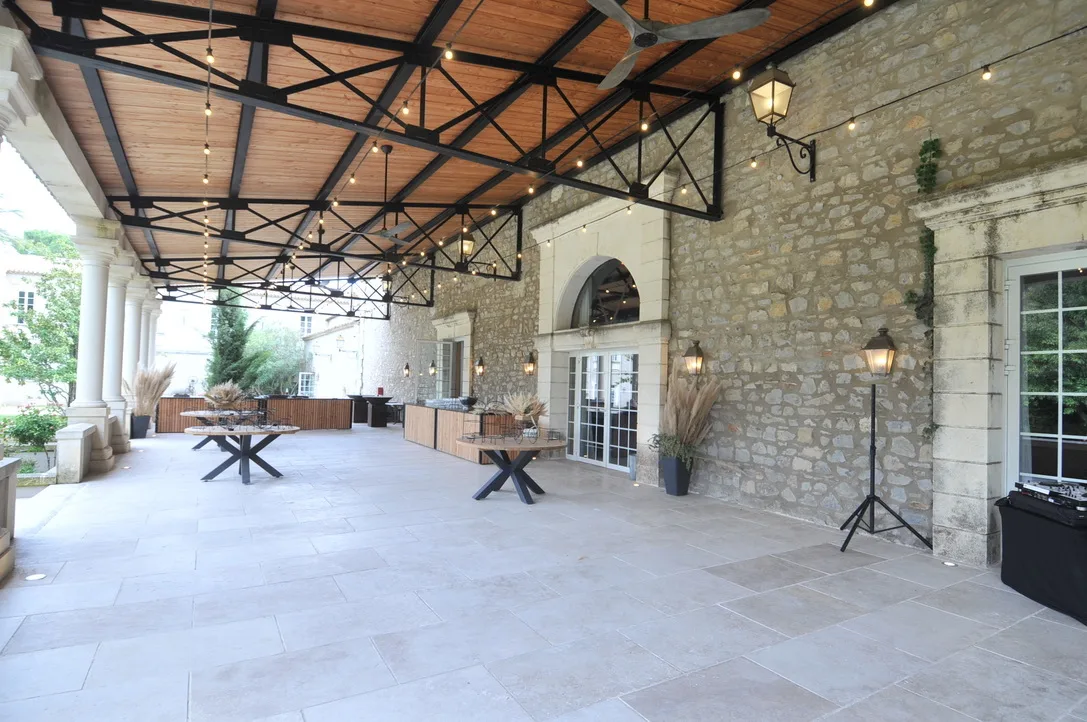 Préau couvert 250 m2 - charpente Eiffel et sol en pierre, guirlandes ginguettes allumées
