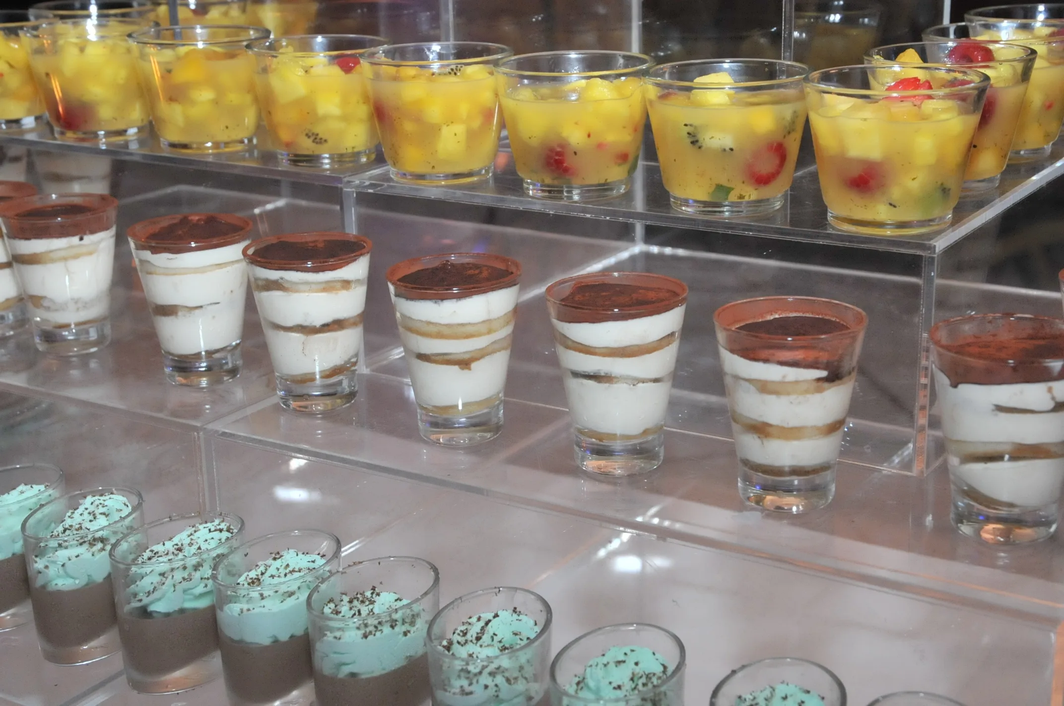 verrines de tiramisu, salade de fruits et autres desserts présentées sur un buffet