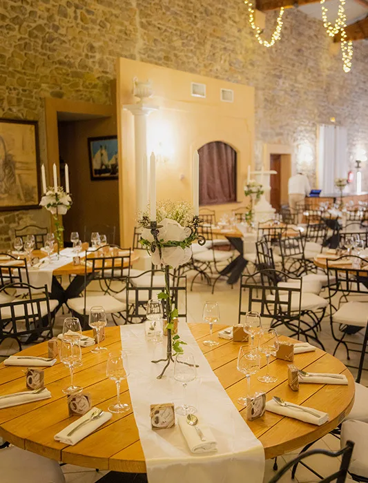 tables dressées et décorées de fleurs et ambiance chaleureuse à l'intérieur de la salle du Grand Malherbes à l'occasion d'un mariage