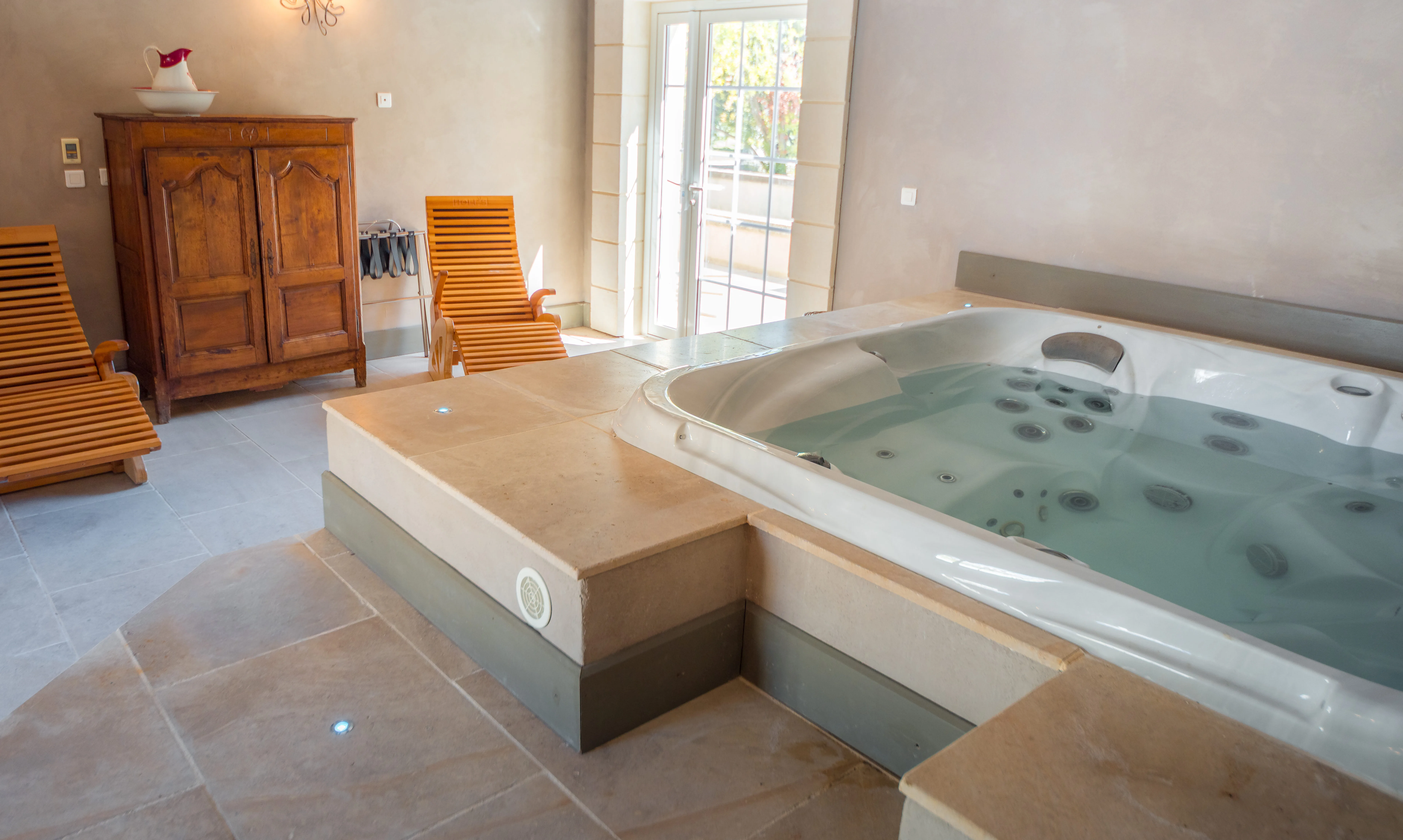 jacuzzi et transats en bois de l'espace spa du Domaine